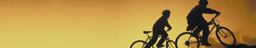 a photo of two cyclists silhouetted against a sunset